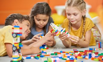 Group of kids playing with plastic blocks. Children playing with constructor. Developing toys for kids.