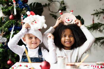 Happy little girl near wooden Christmas tree with handmade corru
