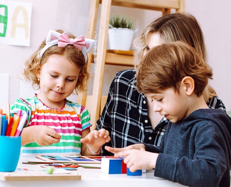 English teacher with children have fun and playing games, learning alphabet and numbers by arts in kid development childcare center. Daycare and babysitting. English school, study british and american